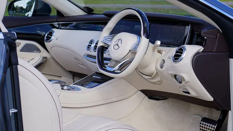 Detailed clean beige leather luxury Mercedes-AMG car interior with polished dashboard and trim